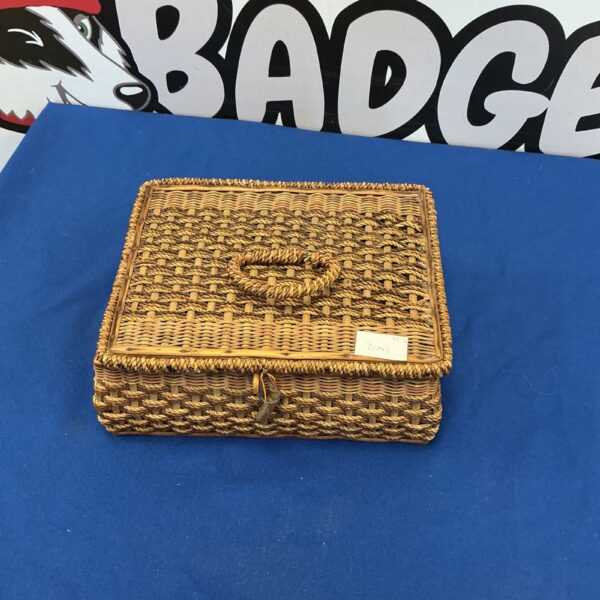 Front view of a vintage wicker sewing basket with clasp.