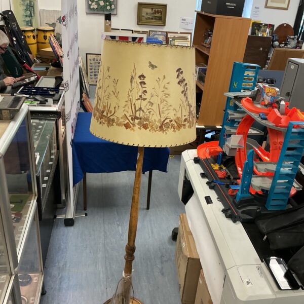 Vintage standard lamp with floral shade, retro wooden design.