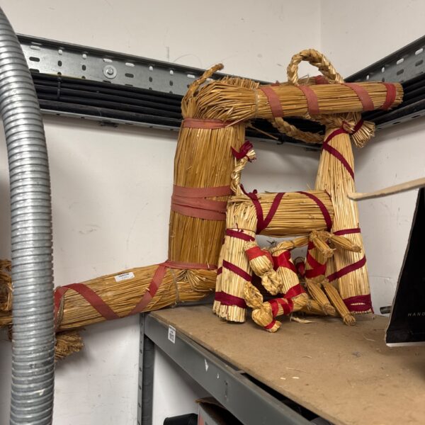 Vintage straw animal sculpture with colourful ribbons.