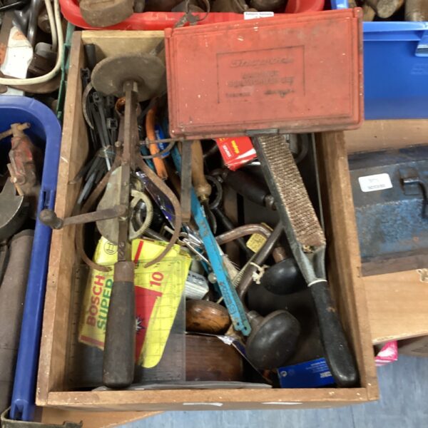 Vintage crate filled with assorted tool handles and parts.