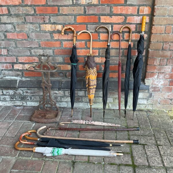 Victorian cast iron umbrella rack with vintage umbrellas displayed.