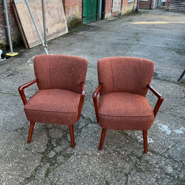 Two vintage upholstered chairs with wood legs.