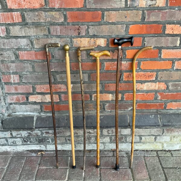 Collection of vintage walking sticks with carved handles.
