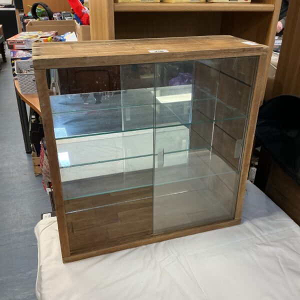 Vintage wooden cabinet with glass door for display.