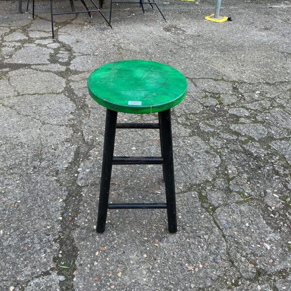 Vintage wooden kitchen stool with a circular seat and four legs.