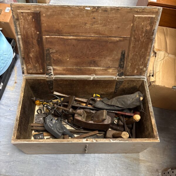 Vintage woodworking tools in a weathered wooden storage box.