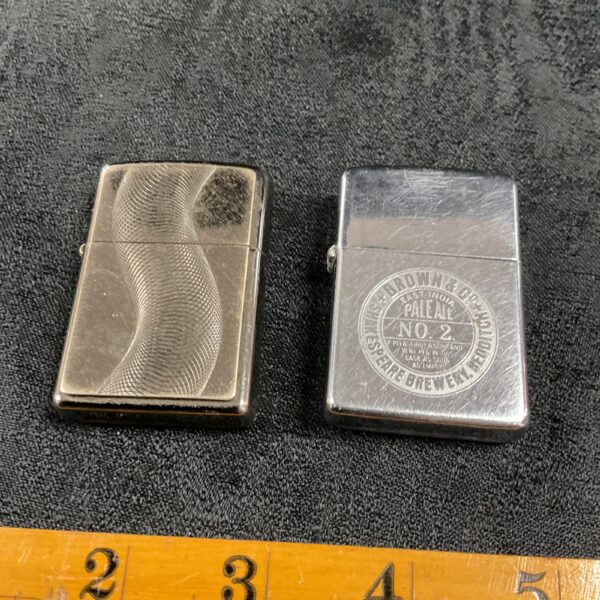 Vintage Zippo lighters with engraved metal detailing.