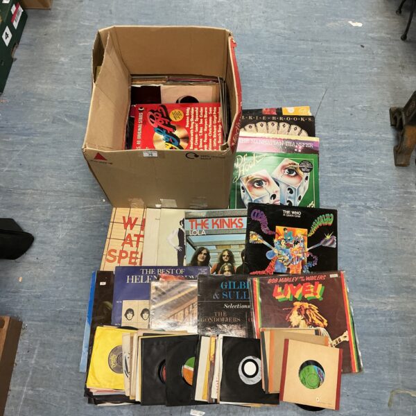 Assorted vinyl records including The Who and The Kinks in a cardboard box.
