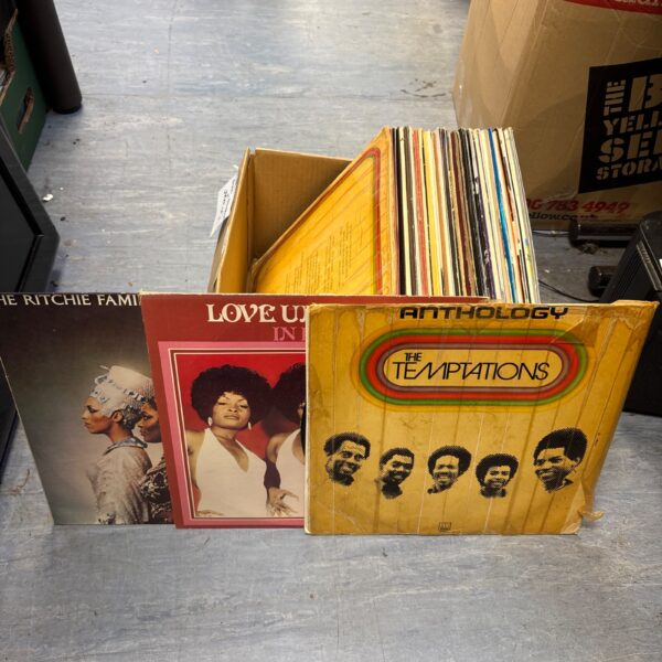 Stack of vintage vinyl records in a cardboard box.