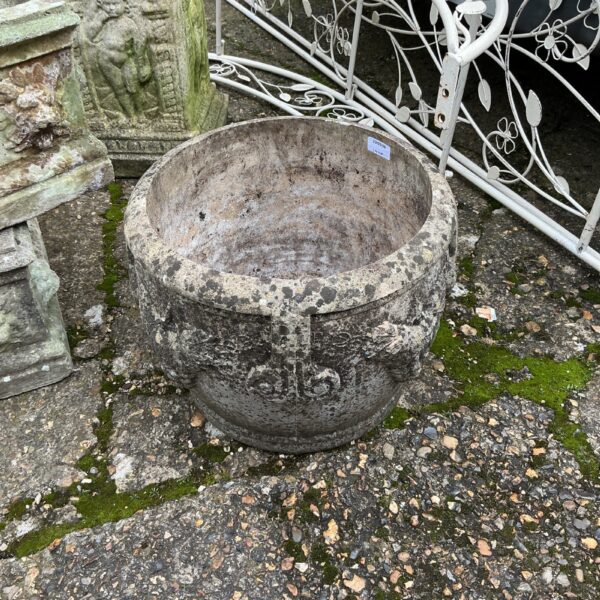 Weathered stone garden planter with moss, ideal for outdoor use.