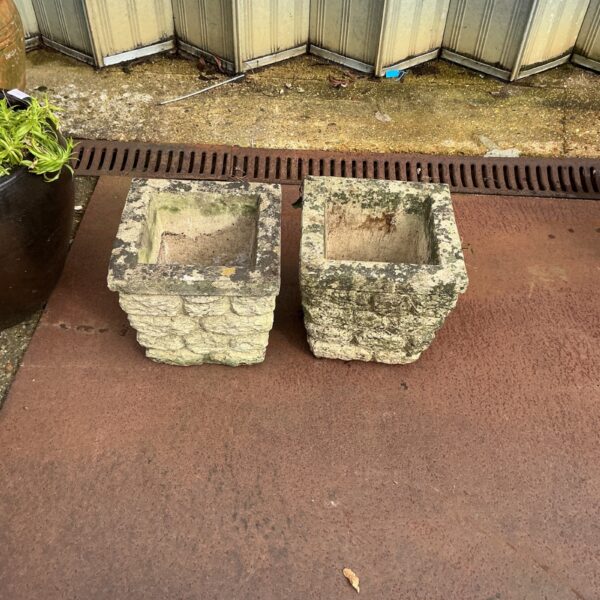Weathered stone garden planters for outdoor display.