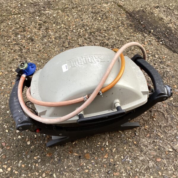 Vintage Weber gas BBQ burner with connecting gas line.