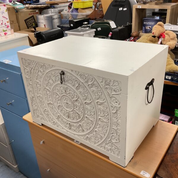 White storage chest with detailed engraved floral design.