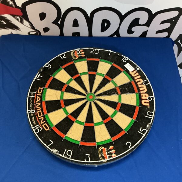 Winmau dartboard with visible wear, ideal for game play.