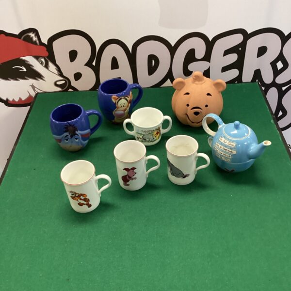 A collection of colourful Winnie the Pooh character mugs.