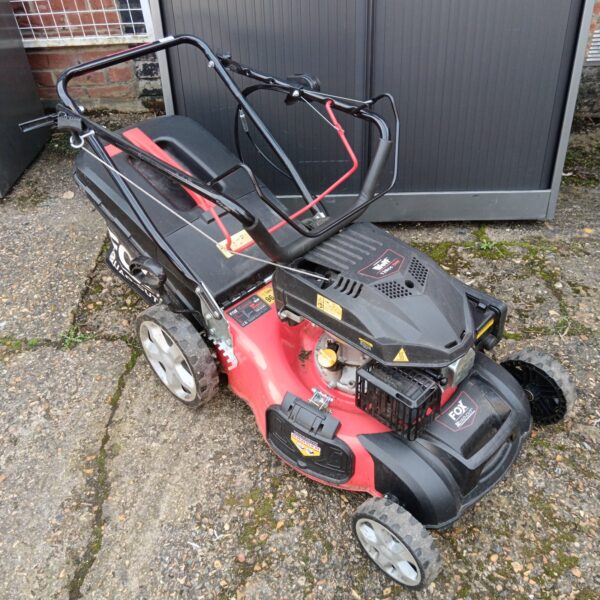 Red and black Wolf Quad Cut petrol lawnmower in used condition.