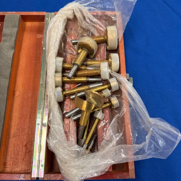 Vintage wood boring router bits in wooden case for woodworking.