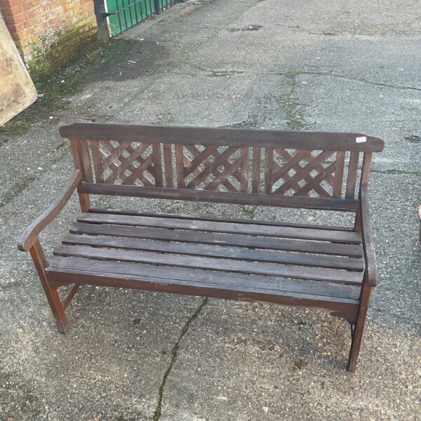 Rustic wooden garden bench in a garden setting.