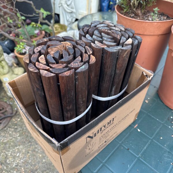 Two rolls of wooden garden border edging for landscaping.