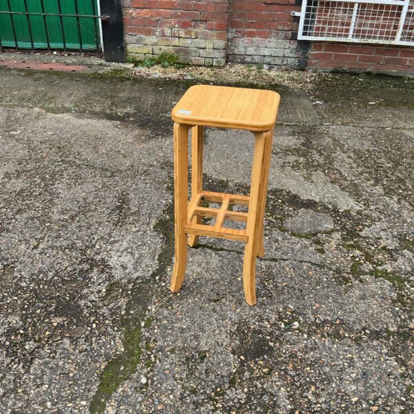Rustic wooden kitchen stool in a farmhouse setting.