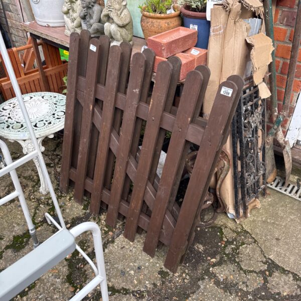 Rustic wooden picket fence panels in a garden setting.