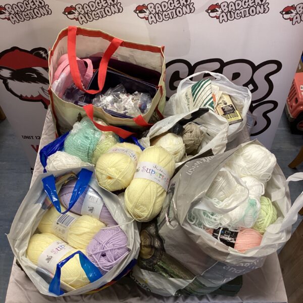 Large bundle of colourful wool and knitting supplies.