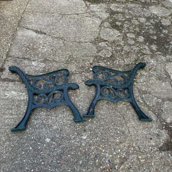Antique wrought iron bench ends with floral design for garden seating.