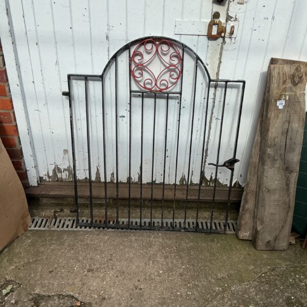 Antique wrought iron garden gate with swirling design.