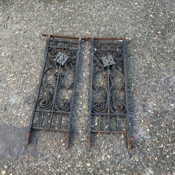 Antique wrought iron panels with intricate scrolling designs for garden decor.