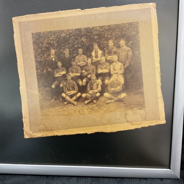 Vintage WWI football team photograph in a framed portrait.