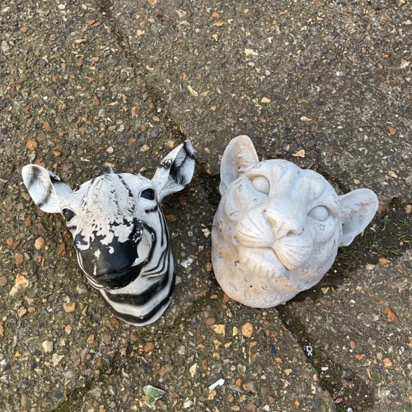 Zebra and leopard head planters for garden or wall display.