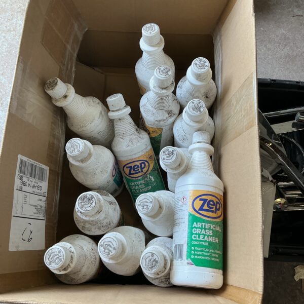 Multiple bottles of Zep artificial grass cleaner in a cardboard box.