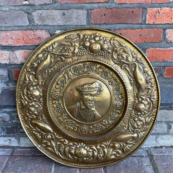 Antique 19th-century brass repousse charger for wall display.