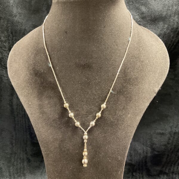 Delicate 925 silver ball necklace on a neutral background.