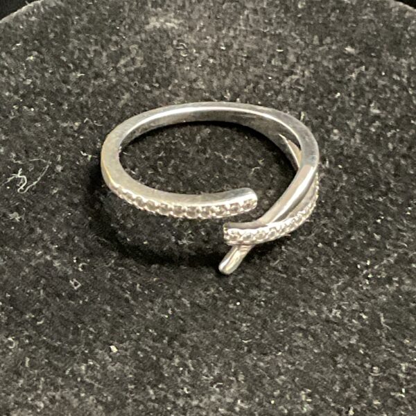 Silver crossover ring with white stones, size O.