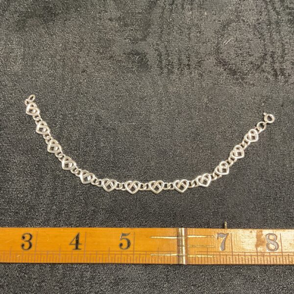 Close-up of a 925 silver heart bracelet with delicate links.