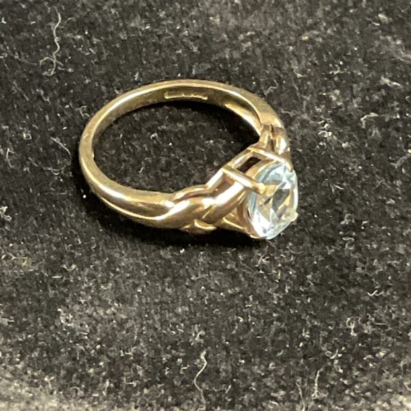 Close-up of a 9ct gold ring with a vibrant topaz gemstone.