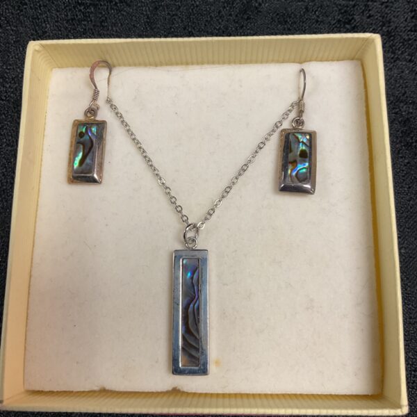 Close-up of abalone silver jewellery set with iridescent shell.