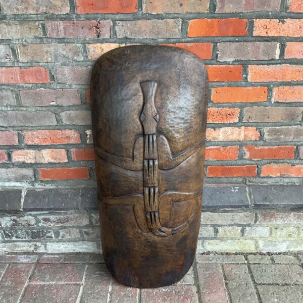 Front view of large African carved shield with crocodile carving.