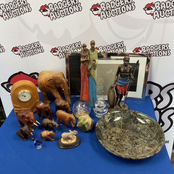 Collection of African tribal figures, wooden elephants, and a stone bowl.