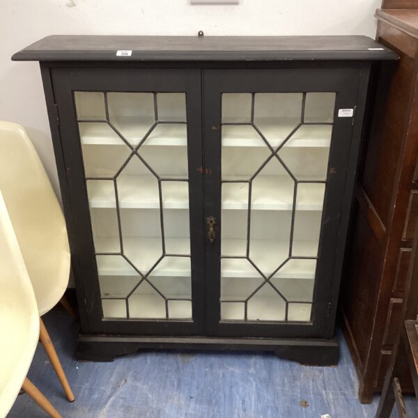Antique astral glazed cabinet with geometric glass panels.