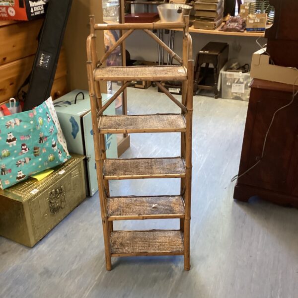 Antique bamboo shelving unit with four tiers for display.