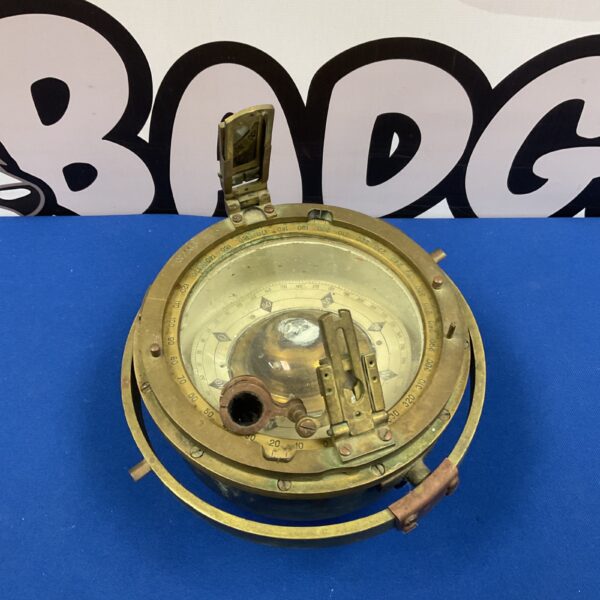 Antique brass ships compass with gimbal mount for nautical navigation.