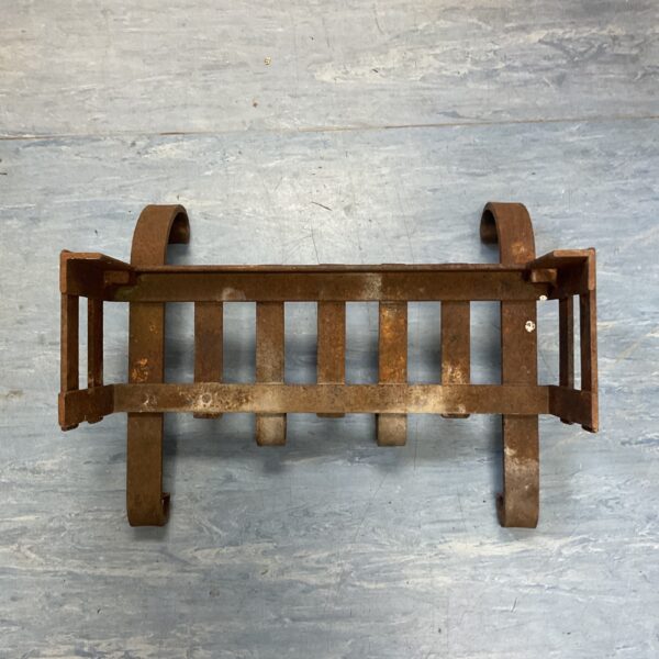 Antique cast iron fire grate for vintage fireplace restoration.