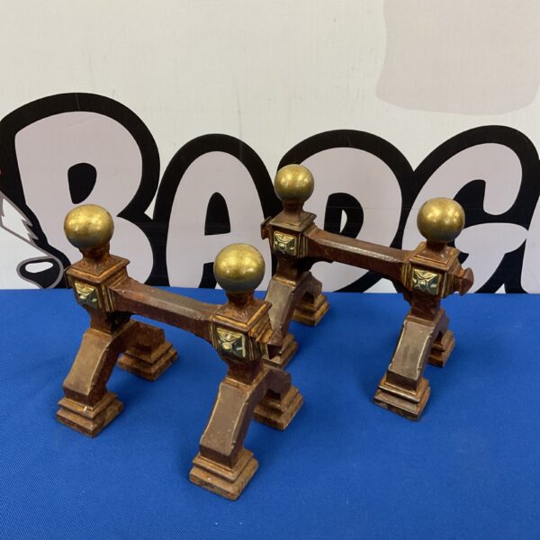Antique cast iron and brass fireplace tool rests, ornate design.
