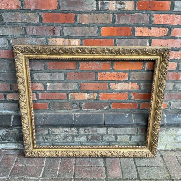 Large antique gilt picture frame with ornate detailing.