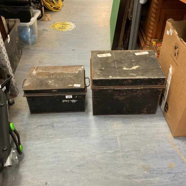 Two antique metal storage boxes with signs of wear.
