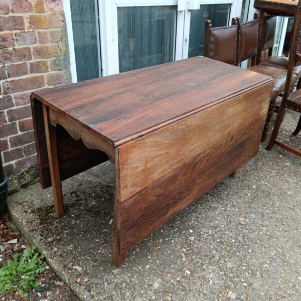 Antique oak drop leaf table with leaves up.