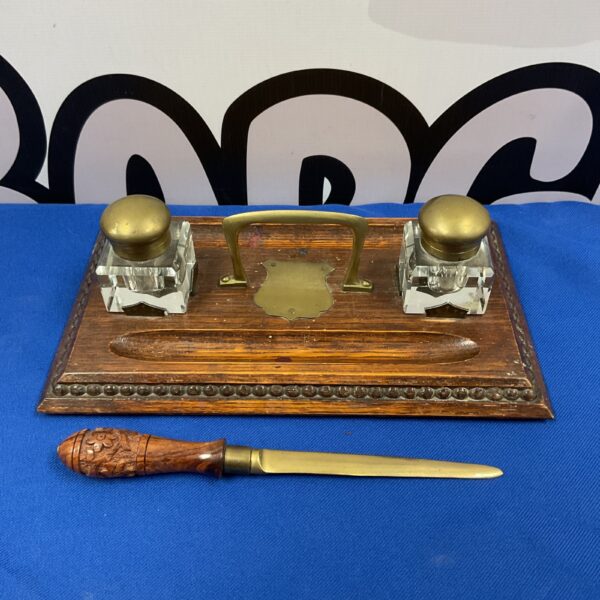 Antique oak pen stand with glass inkwells and letter opener.
