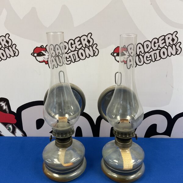 Antique pair of wall-mounted glass oil lamps with metal fittings.